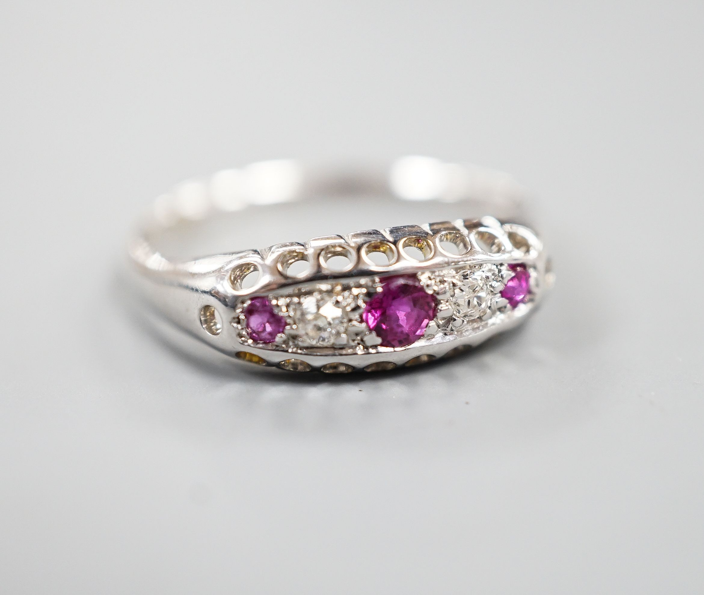 A George V 18ct white gold three stone ruby and two stone diamond ring, size P/Q, gross weight 2.3 grams.